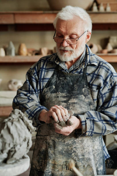 istock Man sculpting figures out of clay 1361273292