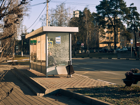 Public transport stop in the city (bus stop), cold autumn morning, the sun is shining, urban landscape