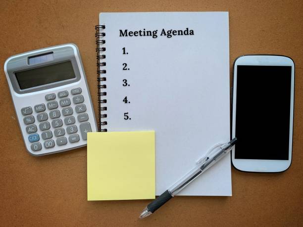 istock Meeting agenda text on notepad with stationery and smart phone background. 1361279206
