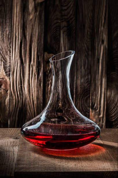 vertikale ansicht dekanter mit rotwein auf jahrgangshintergrund - decanter wine wineglass red wine stock-fotos und bilder
