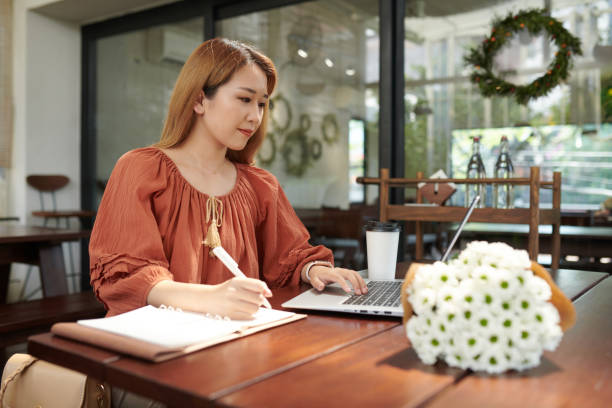 istock Woman Working on Laptop in Cafe 1361282978