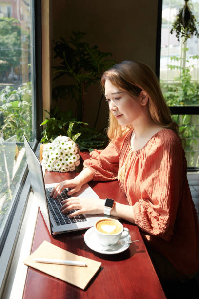istock Woman Working on Laptop in Cafe 1361283001
