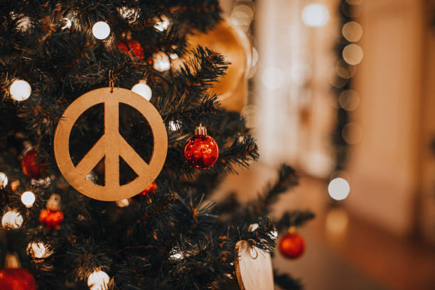 Christmas decoration with hippie icon figurine hanging on a Christmas tree.