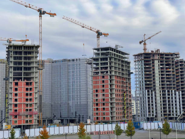 istock Yellow cranes over building site with dramatic clouds in background 1361284154
