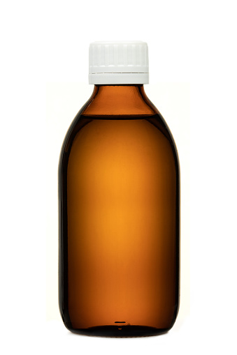 Brown colored transparent glass bottle with white cap, filled with liquid, no label, isolated on white background