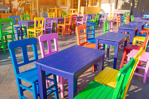 Cute colorful wooden tables and chairs in the outdoor cafe at the resort