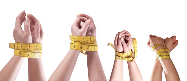 Female hands wrapped around with measuring tape cut out over white