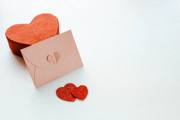 istock A decorative pink Valentine's envelope based on a red heart-shaped gift box. Silvery shiny background, Place for wishes, Two hearts, Symbol of feelings 1361289250