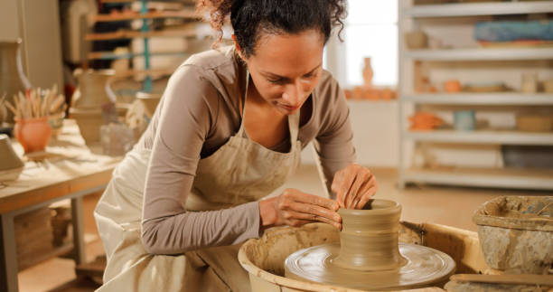 istock Woman making vase on a potter's wheel 1361290653