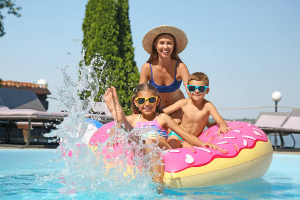 женщина с детьми в бассейне. семейный отдых - fun mother sunglasses family стоковые фото и изображения