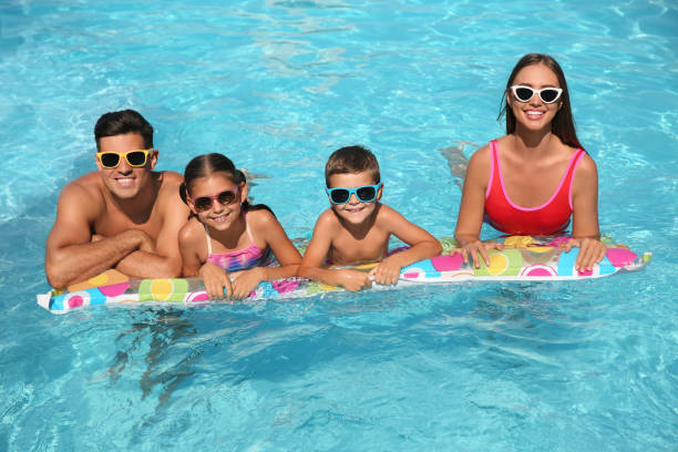 szczęśliwa rodzina na dmuchanym materacu w basenie - fun mother sunglasses family zdjęcia i obrazy z banku zdjęć