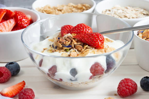 granola, céréales et baies, divers ingrédients délicieux pour le petit-déjeuner dans un bol en verre - dry strawberry dried food fruit photos et images de collection