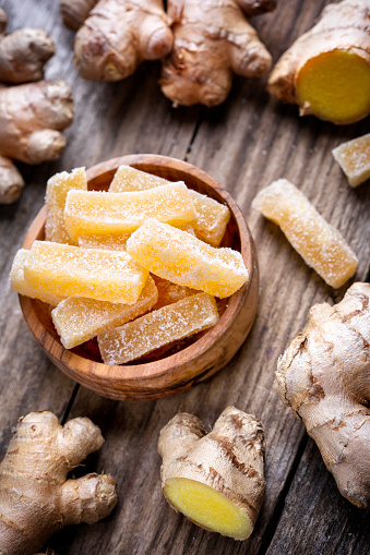 Organic candied ginger sticks in a wooden bowl
