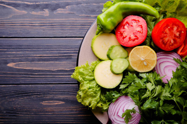 istock Vegetables for salad on a plate on a wooden background 1361301496
