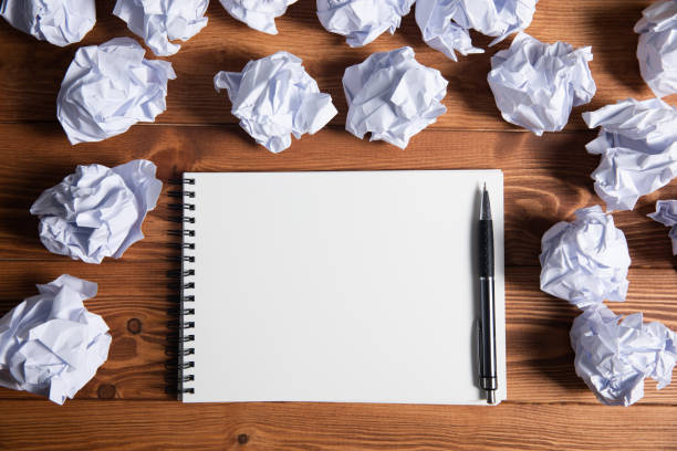 istock wads of papers on the desktop and notepad 1361304133