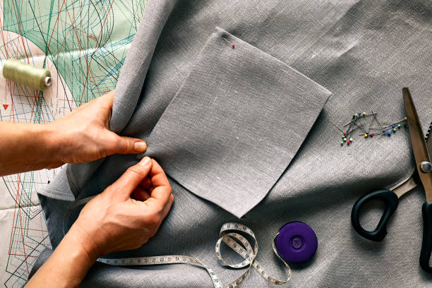 istock Woman is sketching pattern on a linen fabric Seamstress basting and sewing in a small studio Sartorial clothes Fashion studio, tailoring, handmade clothing concept Slow fashion Conscious consumption 1361306712