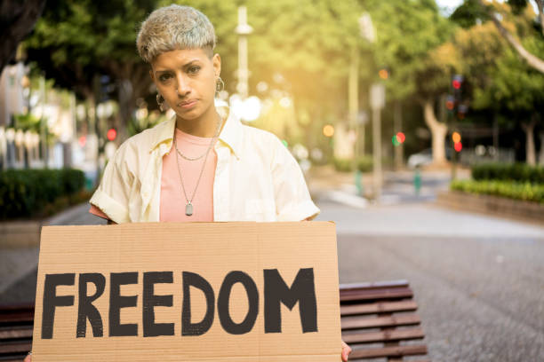 Short hair woman holding banner with freedom word, looking at the camera. Feminist. Protest. Short hair woman holding banner with freedom word, looking at the camera. International Human Right day. Feminist. Protest. reproductive rights stock pictures, royalty-free photos & images
