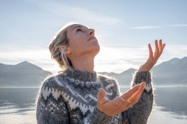 istock Young woman looking up at the sky, praying 1361316292