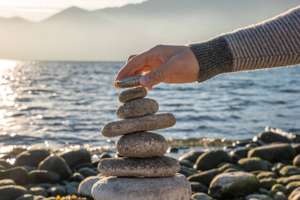 istock Close up on man's hand stacking rocks by the lake 1361316486