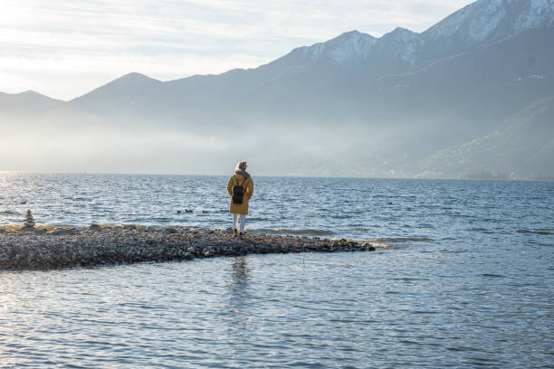 istock Distant woman contemplates magnificent lake scenery 1361316591