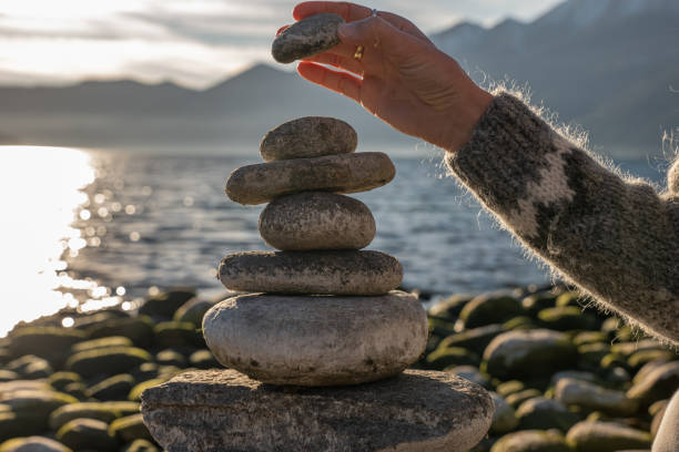 istock Close up on woman's hand stacking rock by the lake 1361319801