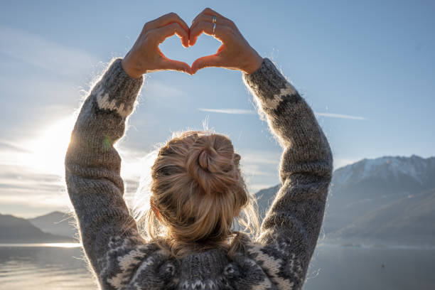 istock Young woman makes a heart shaped finger frame in nature 1361319952