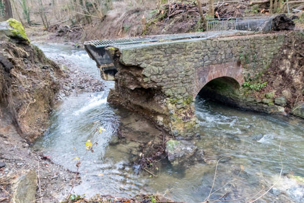 Flooding river creek destroyed a bridge after heavy rain flood water shows the forces of nature and the need for insurance against dangerous weather, windstorms, cyclones, tornados and hurricanes la inundación del arroyo del río destruyó un puente después de una fuerte lluvia de agua de inundación muestra las fuerzas de la naturaleza y la necesidad de un seguro contra el clima peligroso, tormentas de viento, ciclones, tornados y huracanes