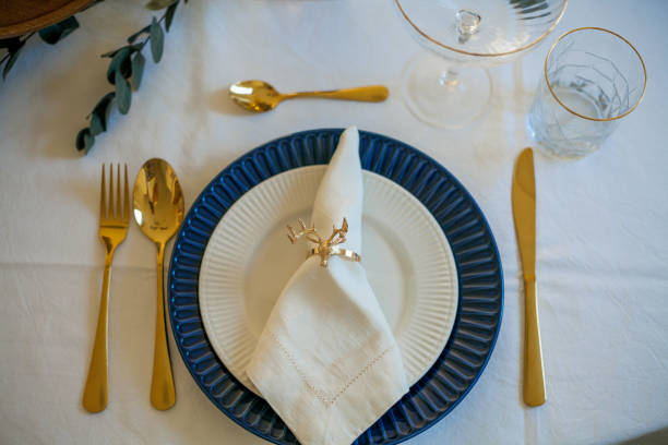 istock Stylish light Christmas table setting with golden cutlery. Festive feasts. Decorations on the New Year's table. 1361320119