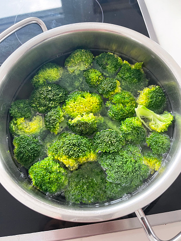 close-up of fresh green broccoli blanching in pot