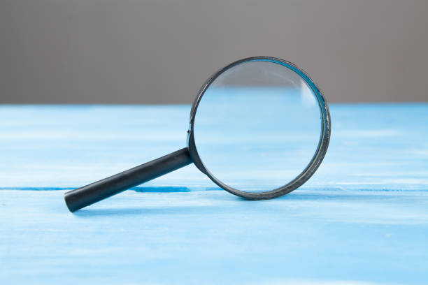 istock magnifier on blue wooden background 1361321540