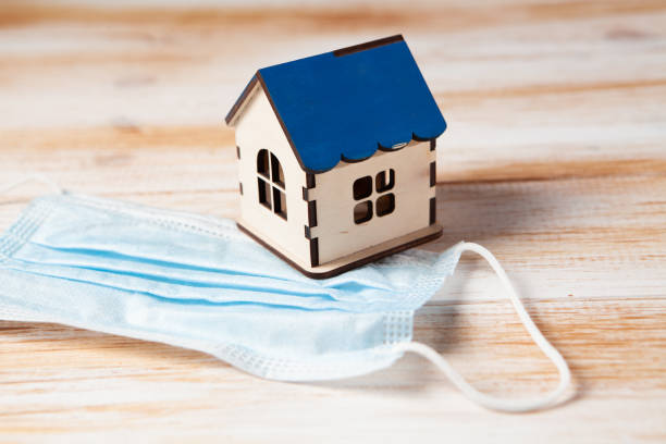 istock mask and house on wooden background 1361321605