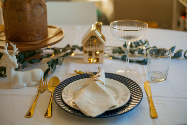 istock Stylish light Christmas table setting with golden cutlery. Festive feasts. Decorations on the New Year's table. 1361325247