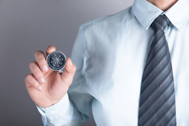 istock a man holding a compass in his hand 1361328560