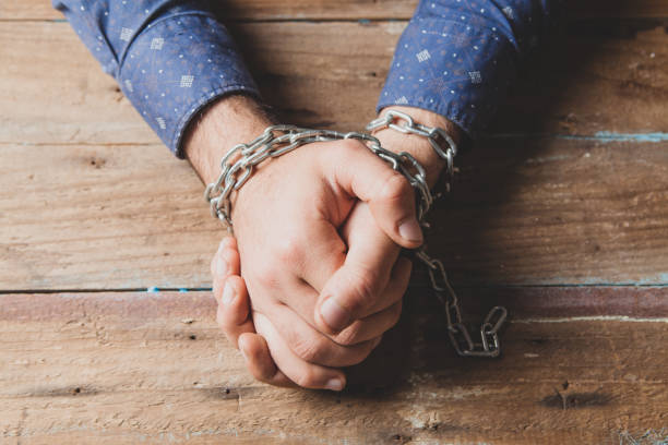 istock the man sits in chains. prisoner concept 1361328561