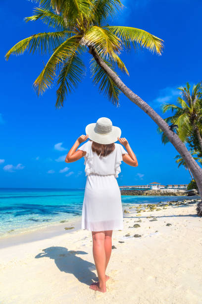 istock Woman standing on the beach 1361328806