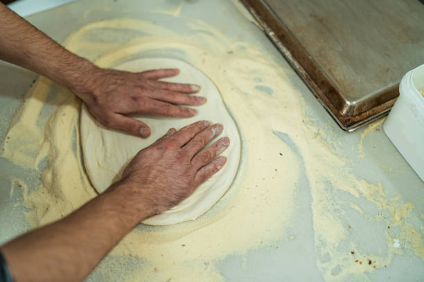 istock Male baker hands kneading dough 1361335136