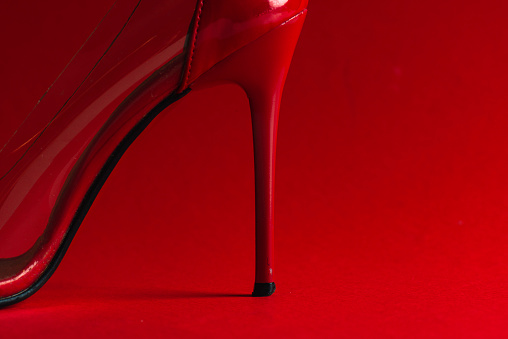 Close-up of red high heel against red background.