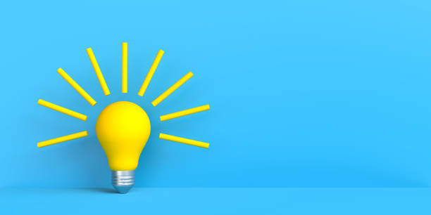 istock Yellow bulb with light beams on blue with copy space 1361339588