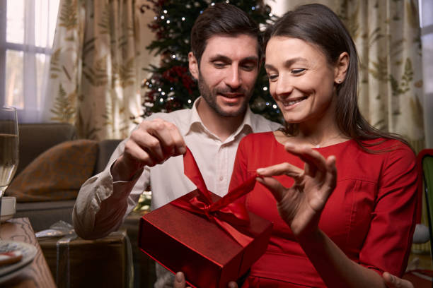 istock Smiling young couple holding gift on Christmas eve 1361340657