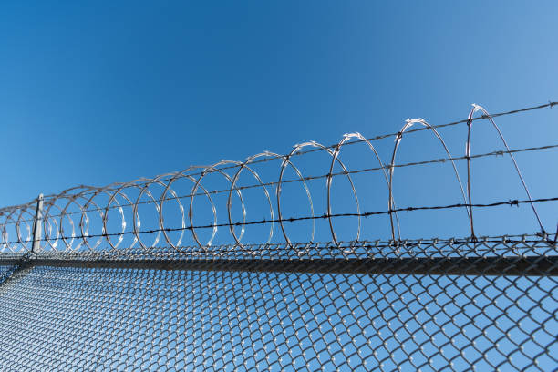 istock coiled razor wire with its sharp steel barb. ensuring safety and security. barbwire 1361347340