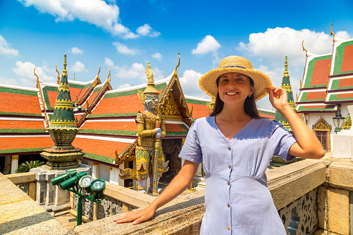 Woman traveler at Demon Guardian in Wat Phra Kaew (Temple of the Emerald Buddha), Grand Palace in Bangkok in a summer day