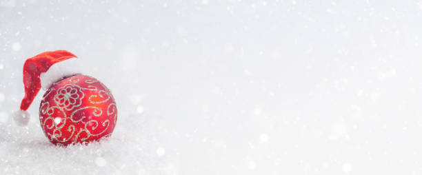 istock Red Glass Ball in Santa's Cap in the Snow. 1361351945