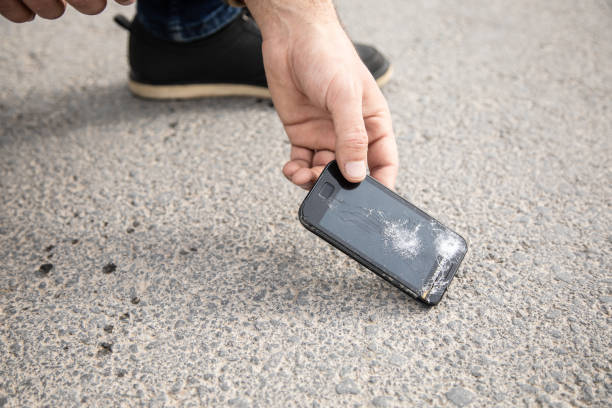 istock a man picks up a broken phone 1361352565