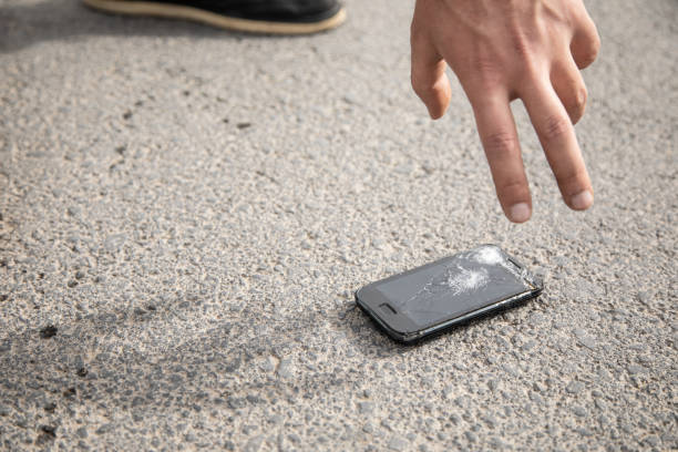 istock a man picks up a broken phone 1361352567