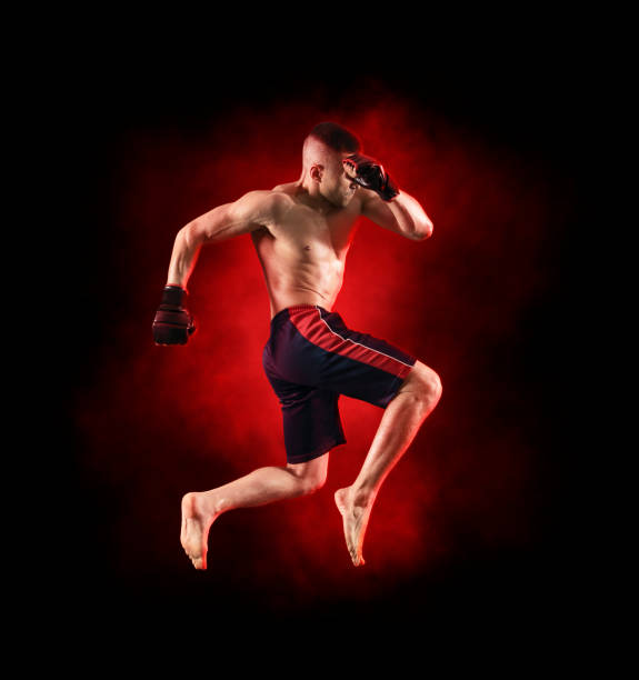 istock MMA male fighter kick. Red smoke background 1361355136