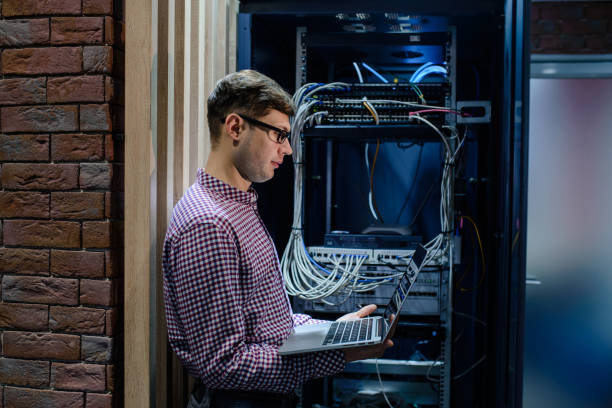 in the server room a technician/ it engineer/ hold the notebook - computer plan engineer fiber imagens e fotografias de stock