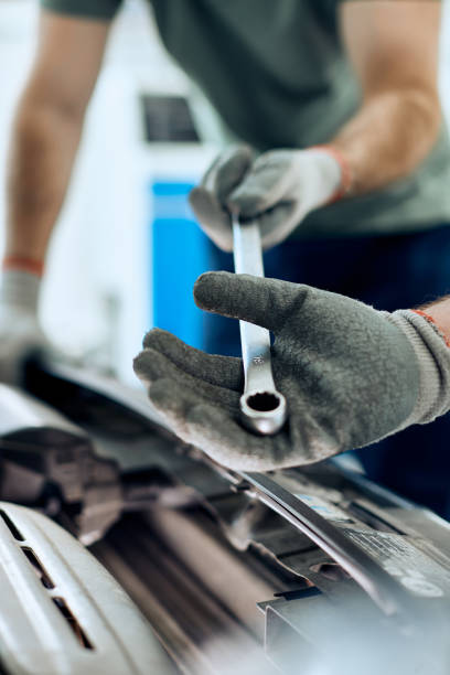 istock Close-up of mechanics cooperating while repairing car engine in a workshop. 1361355634