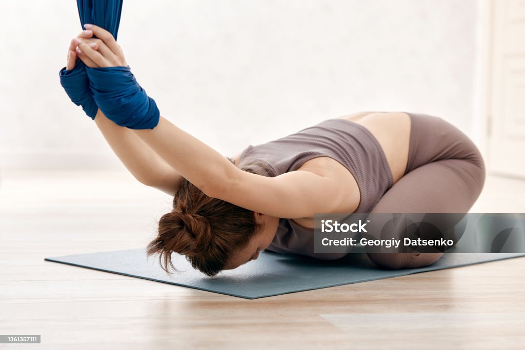 Young beautiful girl practicing aerial yoga in gym Aerial Yoga Stock Photo