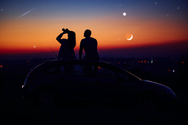 istock Couple stargazing together with a astronomical telescope. 1361357404