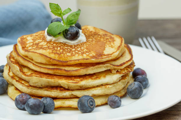 istock stack of pancakes with blueberries on a white plate and a blue napkin 1361357466